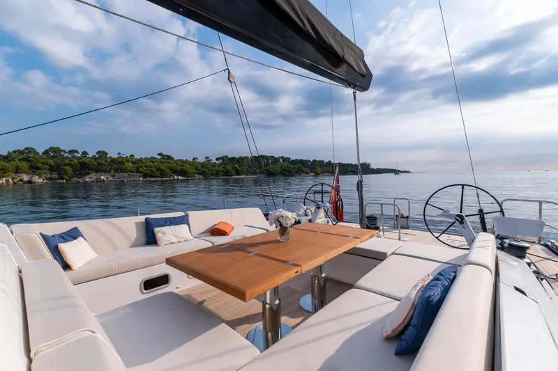 Cloudy Night Yacht Photos Pics Luxurious CNB 76 yacht deck with elegant seating, table, and scenic ocean view, 2019 model.