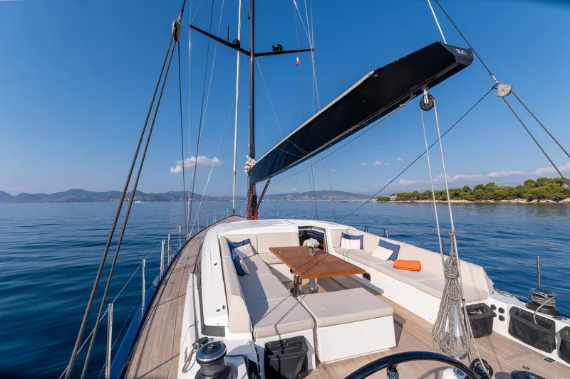 Cloudy Night Yacht Photos Pics Luxurious 2019 CNB 76 yacht deck with seating, sailing on calm blue waters.