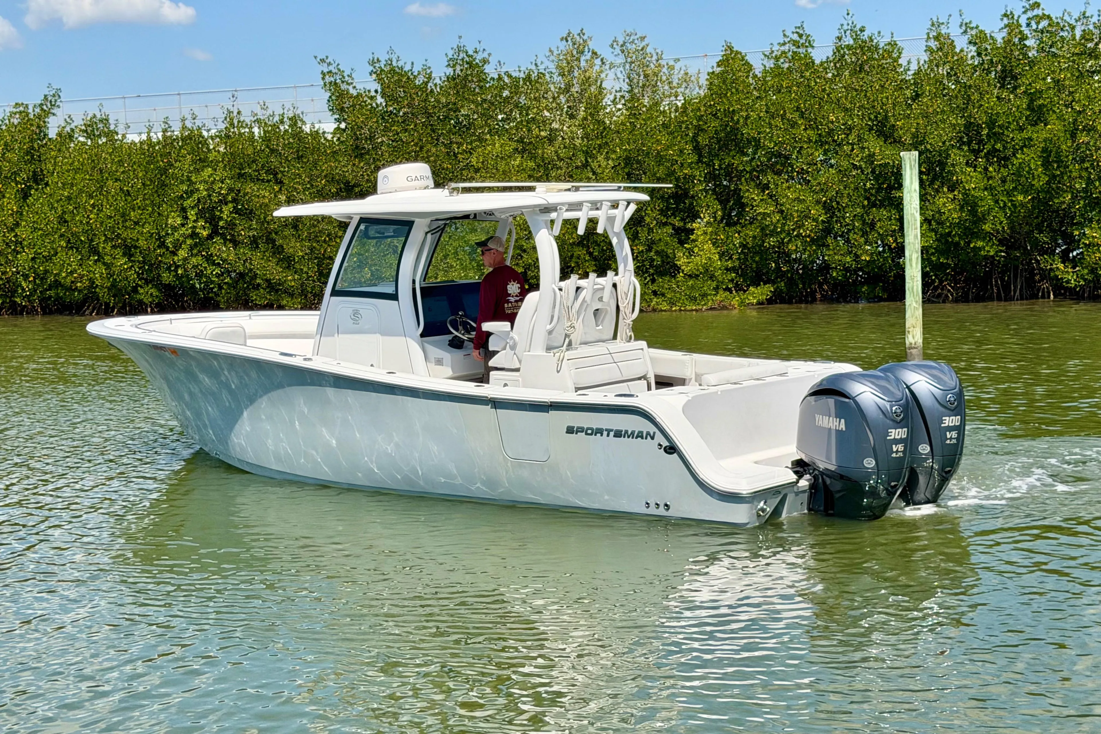 2021 Sportsman Open 302 Center Console boat on calm water with twin Yamaha engines.