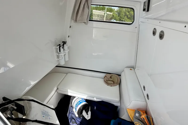  Yacht Photos Pics 2021 Sportsman Open 302 Center Console cabin interior with seating and storage.