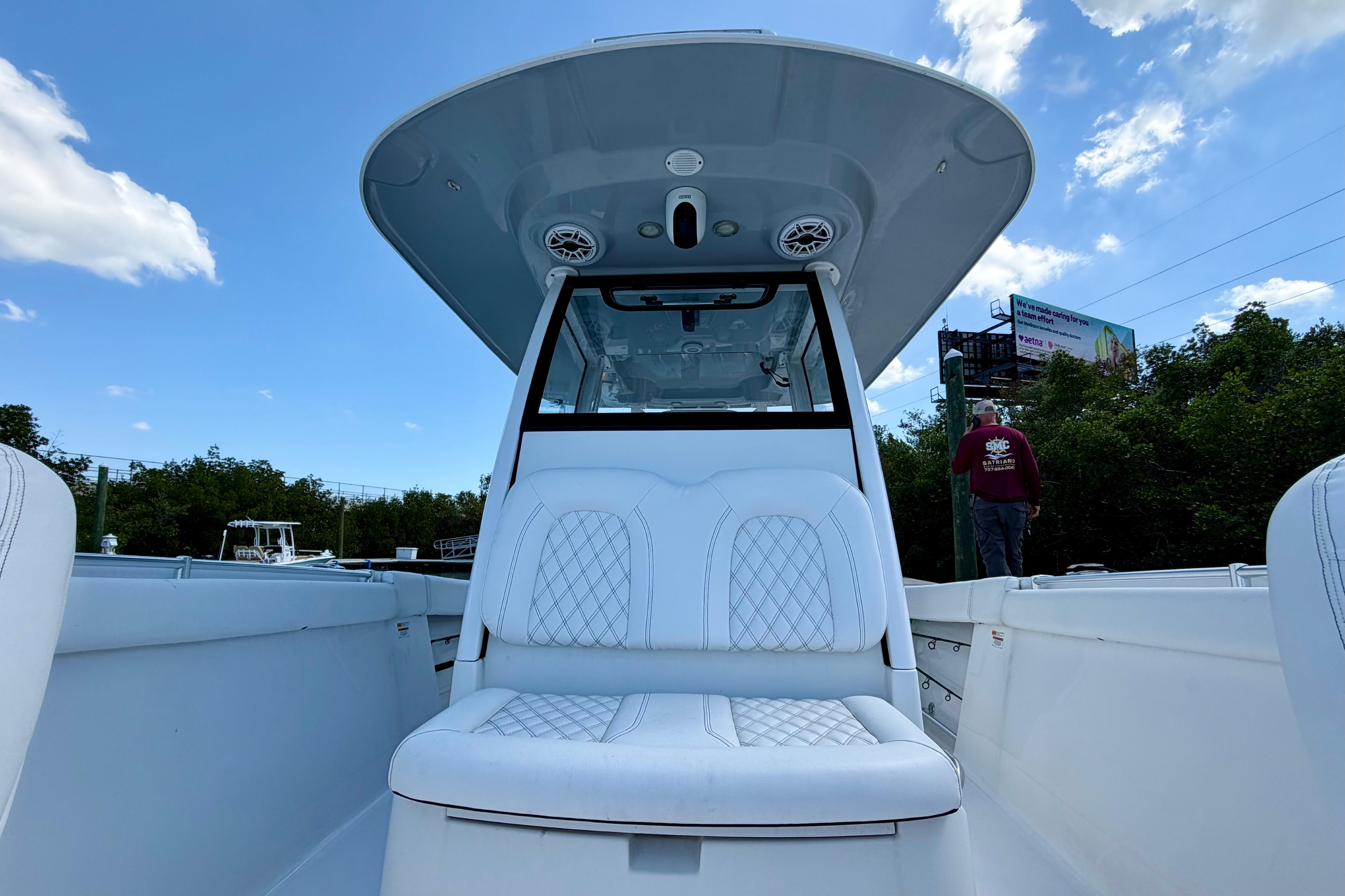 2021 Sportsman Open 302 Center Console boat with white seating under a clear blue sky.