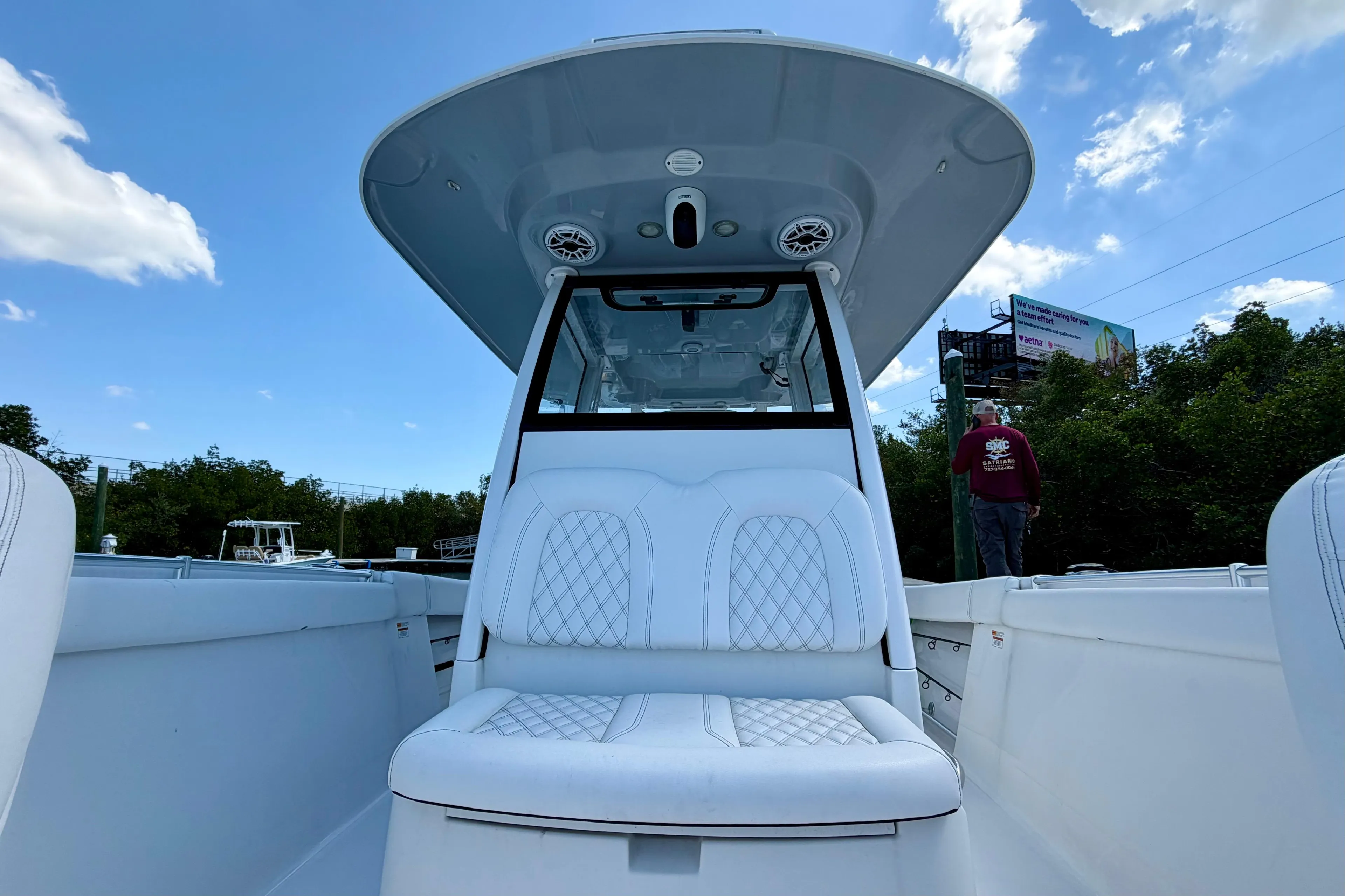 2021 Sportsman Open 302 Center Console boat with white seating under a clear blue sky.