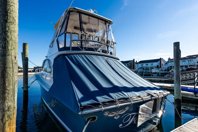 Falcon Yacht Photos Pics 1998 Ocean Yachts 48 Super Sport docked at marina, blue cover, clear sky.