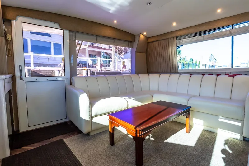 Falcon Yacht Photos Pics Luxurious interior of 1998 Ocean Yachts 48 Super Sport with white seating and wooden table.