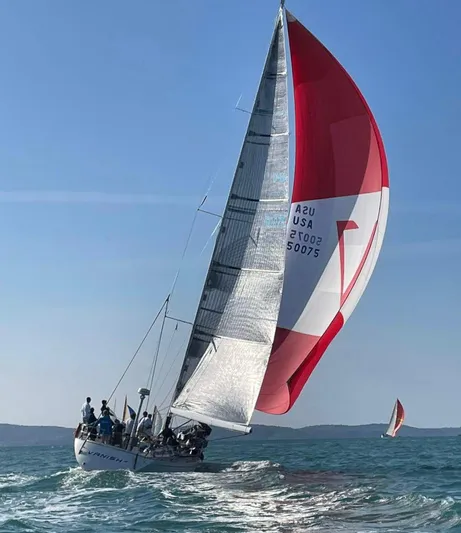  Yacht Photos Pics Sailing yacht Nautor Swan 56, 1999 model, with red and white spinnaker on open sea.