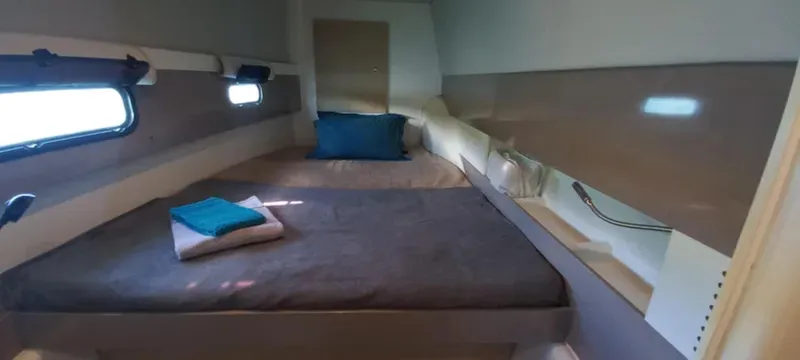  Yacht Photos Pics Cozy cabin interior of 2017 Bali 4.0 yacht with bed and porthole windows.