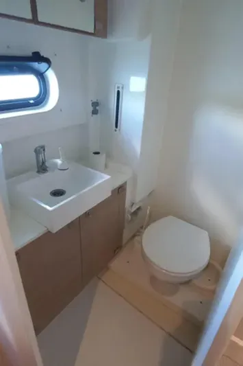  Yacht Photos Pics Compact bathroom in a 2017 Bali 4.0 yacht with sink, toilet, and window.