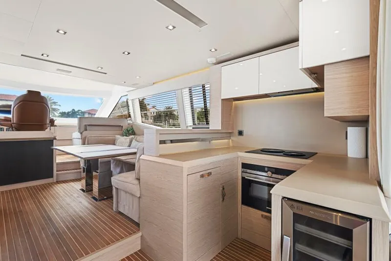 Osiris Yacht Photos Pics Luxurious interior of 2022 Beneteau Monte Carlo 6 yacht with modern kitchen and seating area.