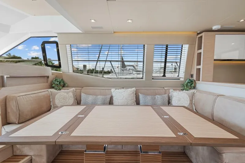 Osiris Yacht Photos Pics Luxurious interior of 2022 Beneteau Monte Carlo 6 yacht with elegant seating and table.