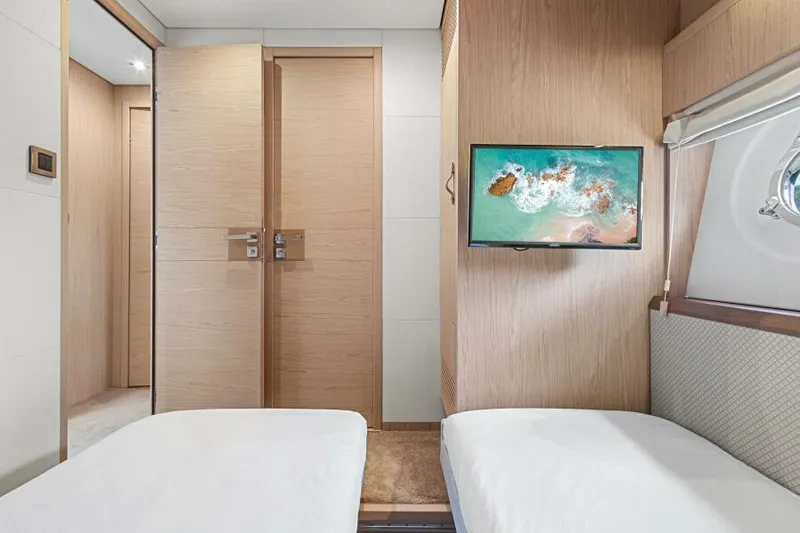 Osiris Yacht Photos Pics Interior of 2022 Beneteau Monte Carlo 6 yacht with twin beds and wall-mounted TV.