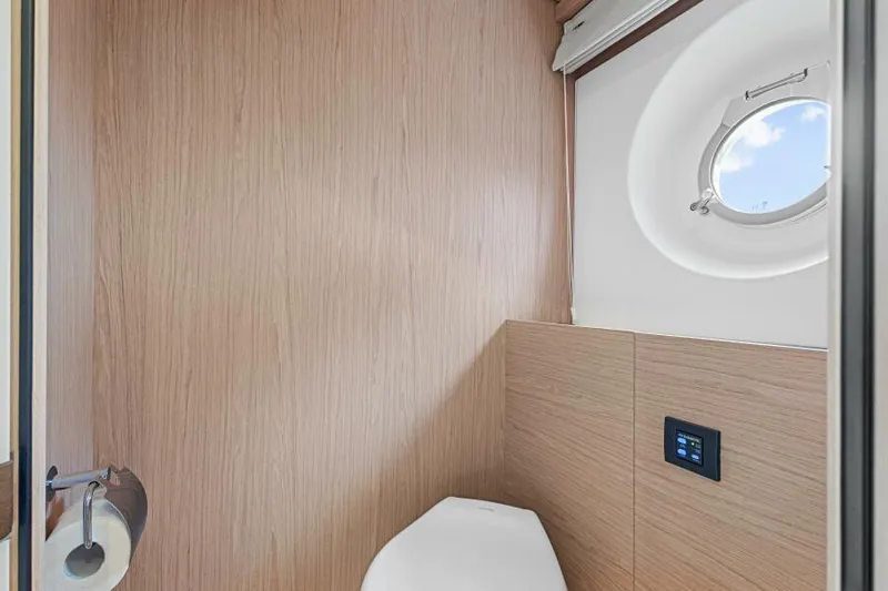 Osiris Yacht Photos Pics Beneteau Monte Carlo 6 2022 yacht bathroom with wood paneling and porthole window.