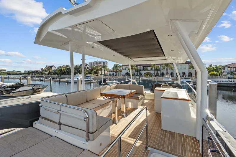 Osiris Yacht Photos Pics Luxurious 2022 Beneteau Monte Carlo 6 yacht with spacious outdoor seating and scenic marina view.