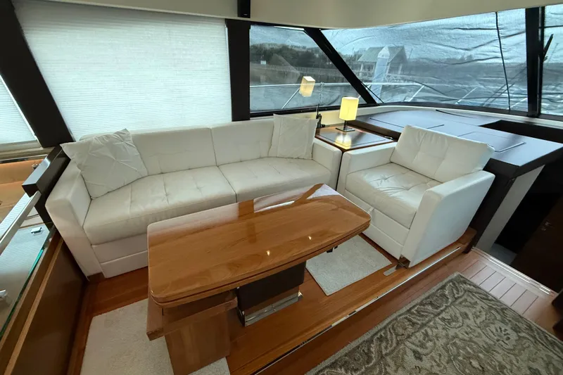  Yacht Photos Pics Luxurious interior of 2016 Tiara Yachts 50 Coupe with white seating and wooden table.