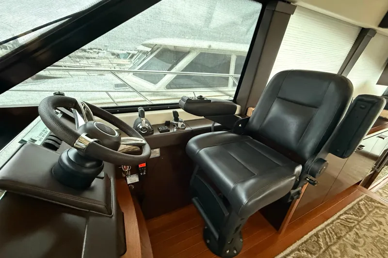  Yacht Photos Pics Helm station of 2016 Tiara Yachts 50 Coupe with leather captain's chair and steering wheel.