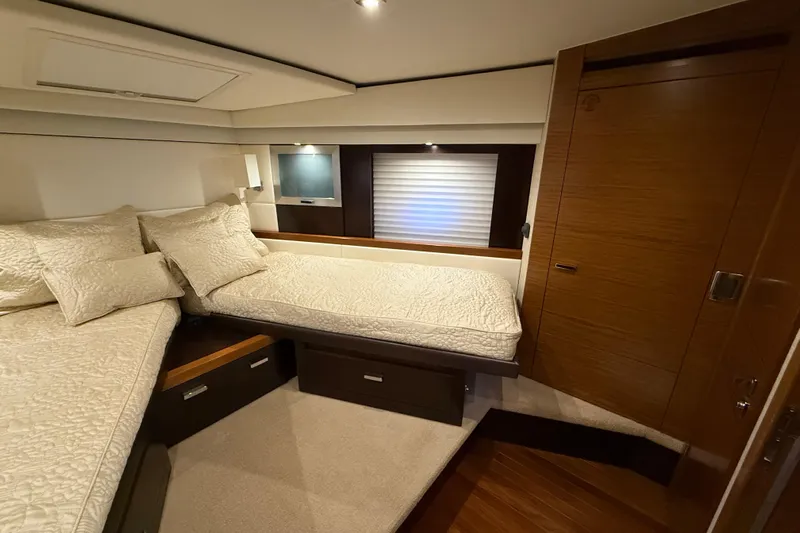  Yacht Photos Pics Luxurious bedroom interior of 2016 Tiara Yachts 50 Coupe with elegant bedding and wood finishes.