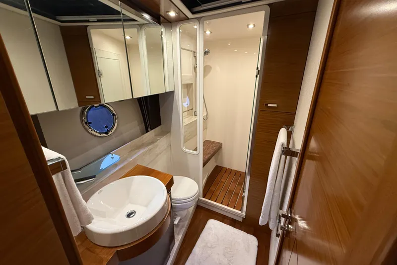  Yacht Photos Pics Luxurious bathroom in 2016 Tiara Yachts 50 Coupe with modern fixtures and wooden accents.