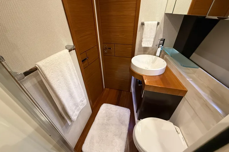  Yacht Photos Pics Luxurious bathroom in 2016 Tiara Yachts 50 Coupe, featuring modern fixtures and elegant wood finishes.