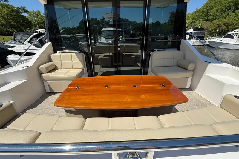  Yacht Photos Pics 2016 Tiara Yachts 50 Coupe with elegant outdoor seating and polished wooden table.