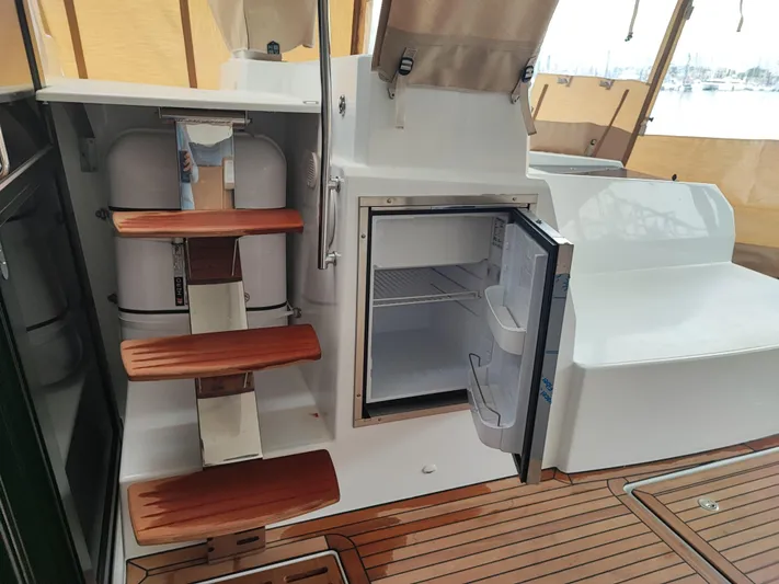  Yacht Photos Pics 2025 Fountaine Pajot Catamaran Aura 51 interior with open fridge and wooden steps.