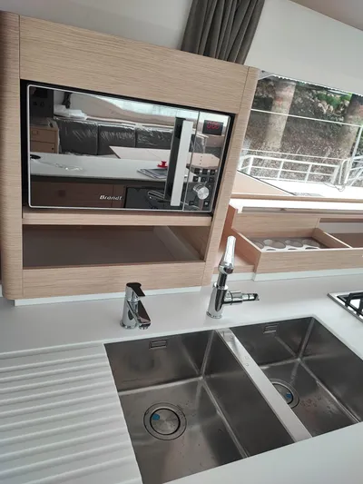  Yacht Photos Pics Modern kitchen interior of 2025 Fountaine Pajot Catamaran Aura 51 with dual sinks and microwave.