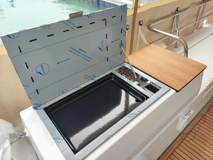  Yacht Photos Pics Outdoor kitchen on 2025 Fountaine Pajot Catamaran Aura 51, featuring a sleek grill and wooden countertop.