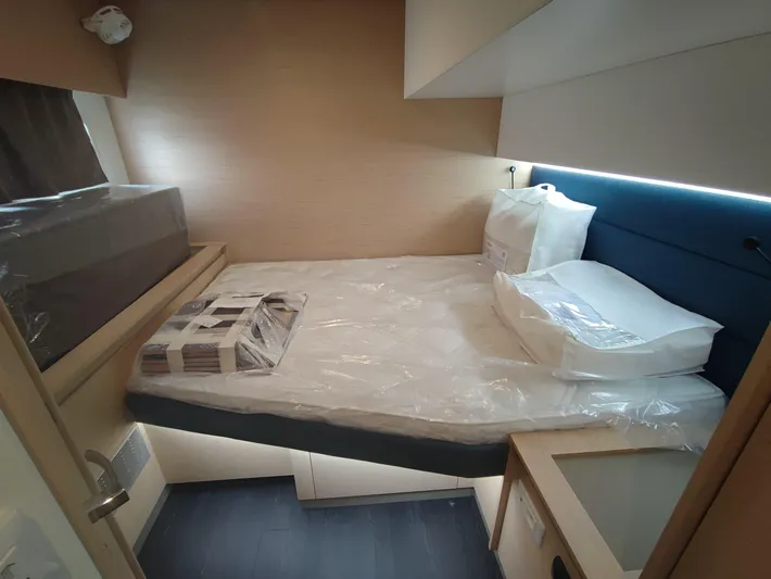  Yacht Photos Pics 2025 Fountaine Pajot Aura 51 catamaran cabin with modern bedding and sleek design.