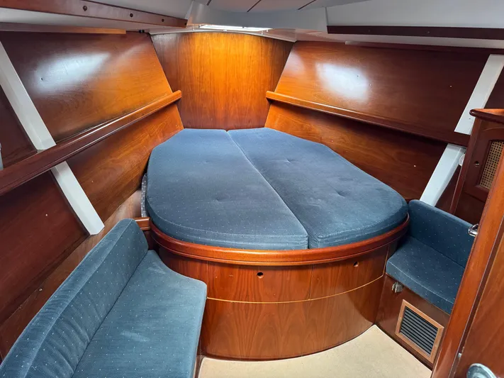 Layla Yacht Photos Pics Interior cabin of 1997 Beneteau Oceanis 461 sailboat with wooden finish and blue upholstery.
