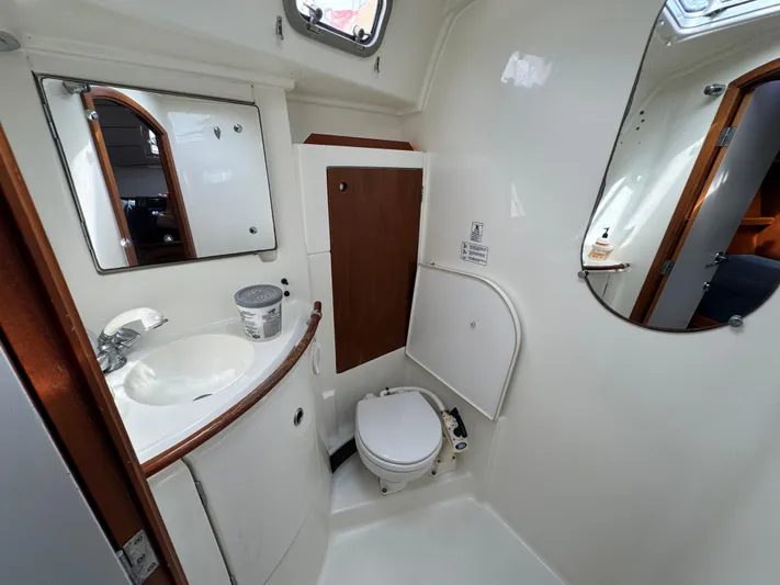 Layla Yacht Photos Pics Bathroom interior of 1997 Beneteau Oceanis 461 yacht, featuring sink, toilet, and mirrors.