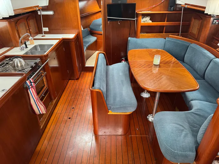Layla Yacht Photos Pics Interior of 1997 Beneteau Oceanis 461 yacht with wooden flooring and cozy seating area.