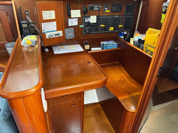 Layla Yacht Photos Pics Navigation station on 1997 Beneteau Oceanis 461 yacht with control panels and wooden finish.