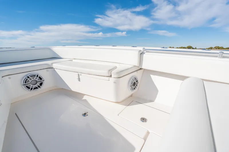 Yacht Photos Pics 2023 Contender 28 Sport boat interior with white seating and speakers under blue sky.