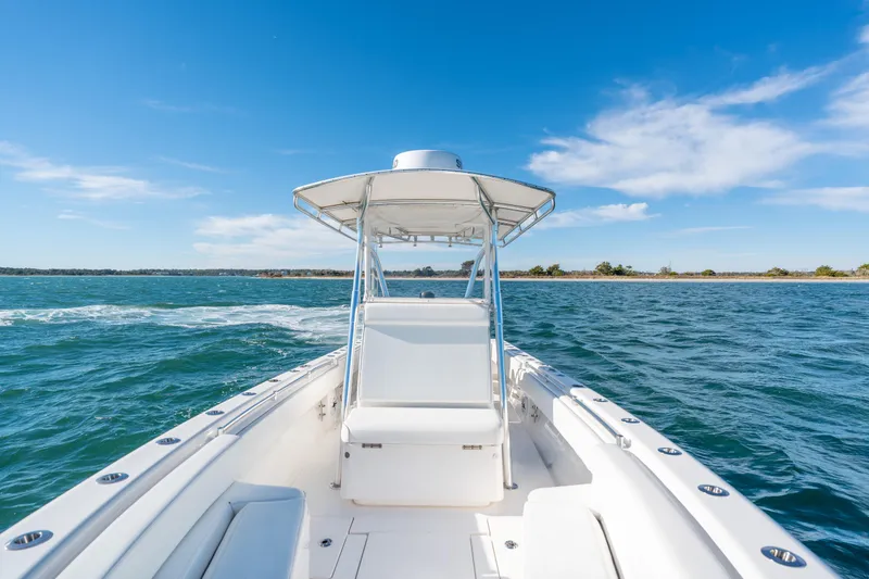  Yacht Photos Pics 2023 Contender 28 Sport boat cruising on open water under clear blue sky.