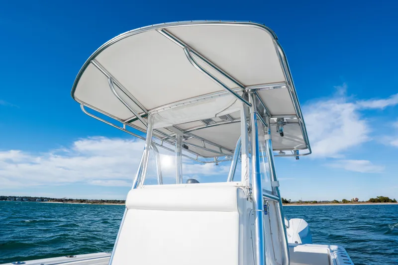  Yacht Photos Pics 2023 Contender 28 Sport boat with T-top on open water under clear blue sky.