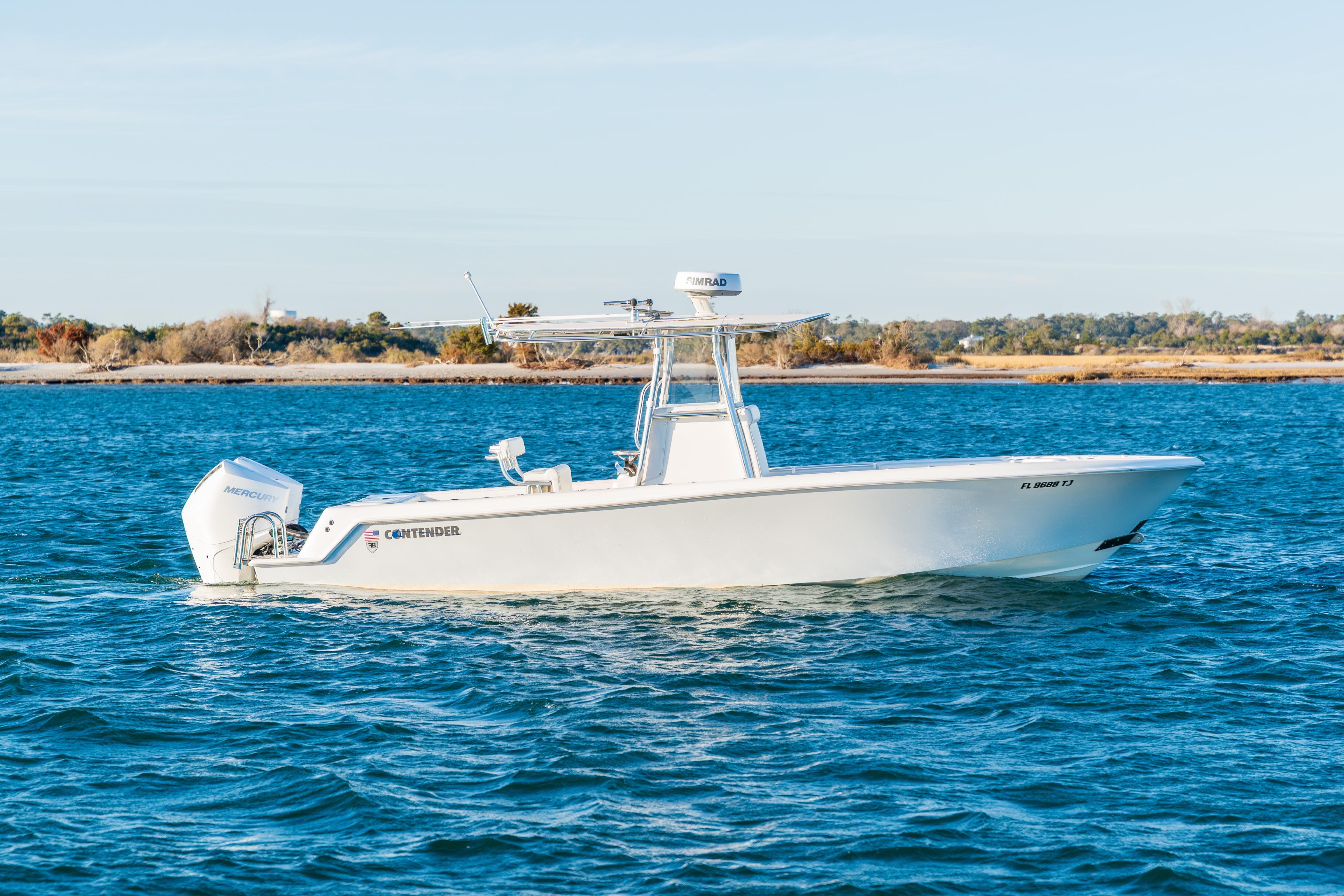 2023 Contender 28 Sport boat on blue water, side view, clear sky background.