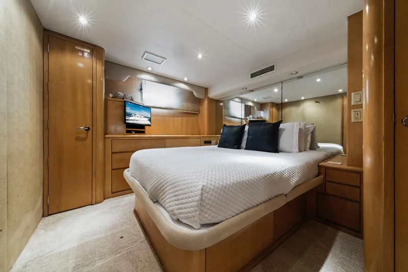  Yacht Photos Pics Luxurious bedroom interior of 2000 Hatteras 74 Cockpit Motor Yacht with modern amenities.