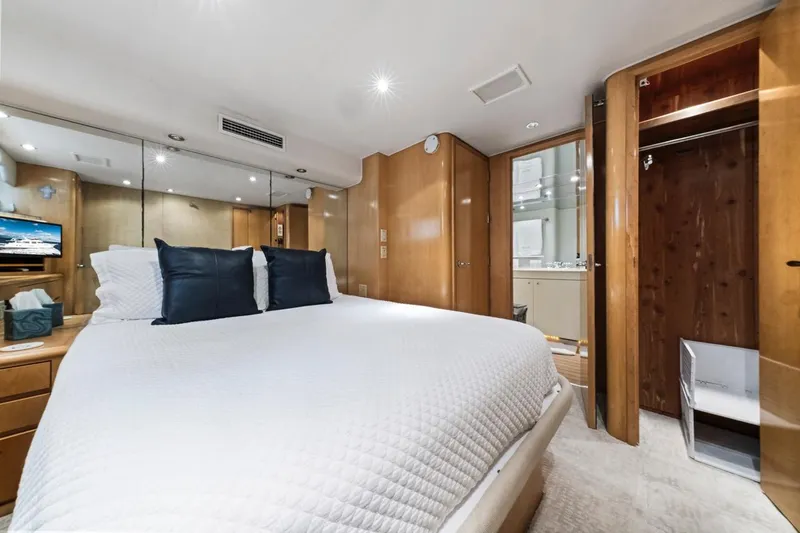  Yacht Photos Pics Luxurious bedroom interior of 2000 Hatteras 74 Cockpit Motor Yacht with modern amenities.