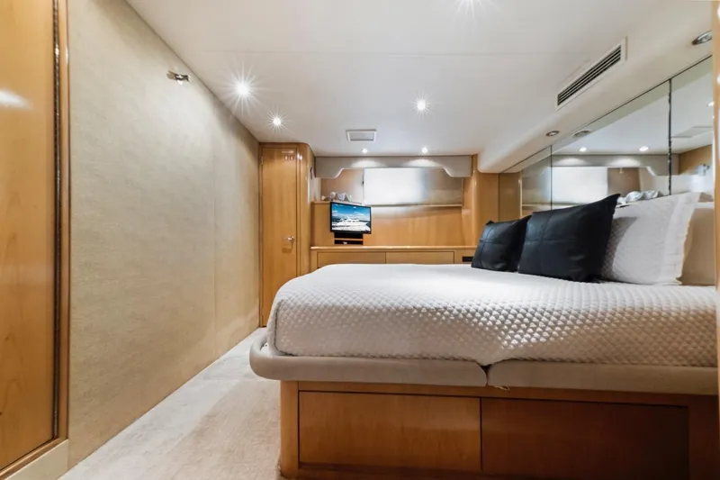  Yacht Photos Pics Luxurious bedroom interior of 2000 Hatteras 74 Cockpit Motor Yacht with modern amenities.