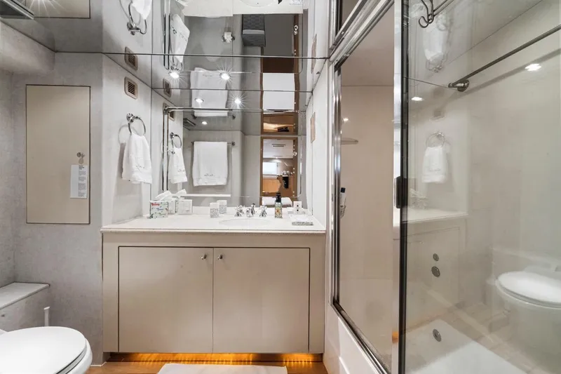  Yacht Photos Pics Luxurious bathroom in 2000 Hatteras 74 Cockpit Motor Yacht with modern fixtures and glass shower.