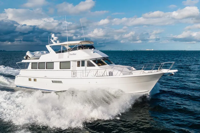  Yacht Photos Pics Hatteras 74 Cockpit Motor Yacht 2000 cruising on open sea under cloudy sky.