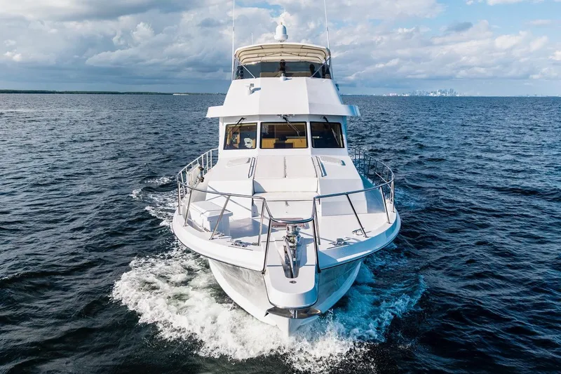  Yacht Photos Pics 2000 Hatteras 74 Cockpit Motor Yacht cruising on open water under a cloudy sky.