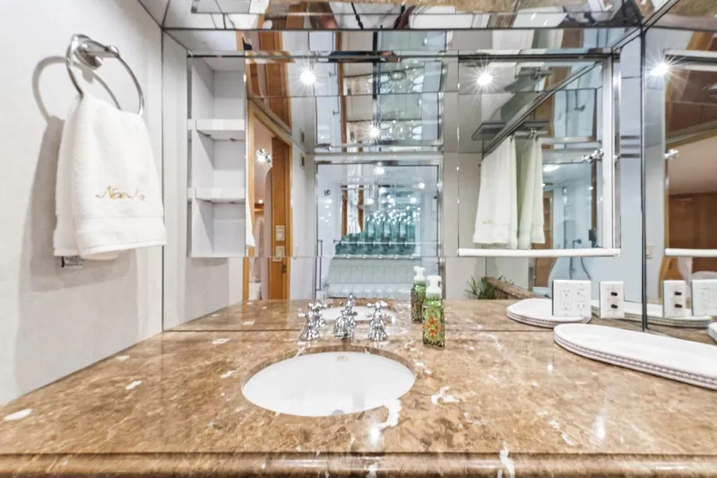  Yacht Photos Pics Luxurious bathroom in 2000 Hatteras 74 Cockpit Motor Yacht with marble countertop and mirrored walls.