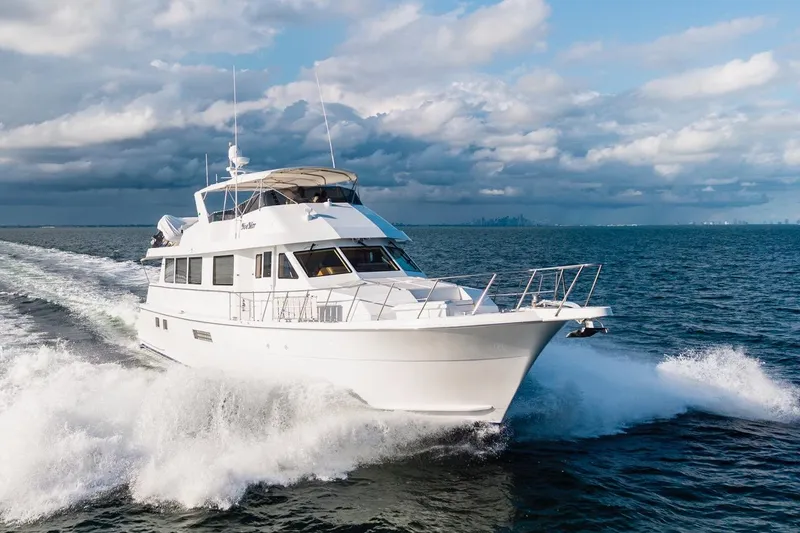  Yacht Photos Pics 2000 Hatteras 74 Cockpit Motor Yacht cruising on open water under cloudy skies.