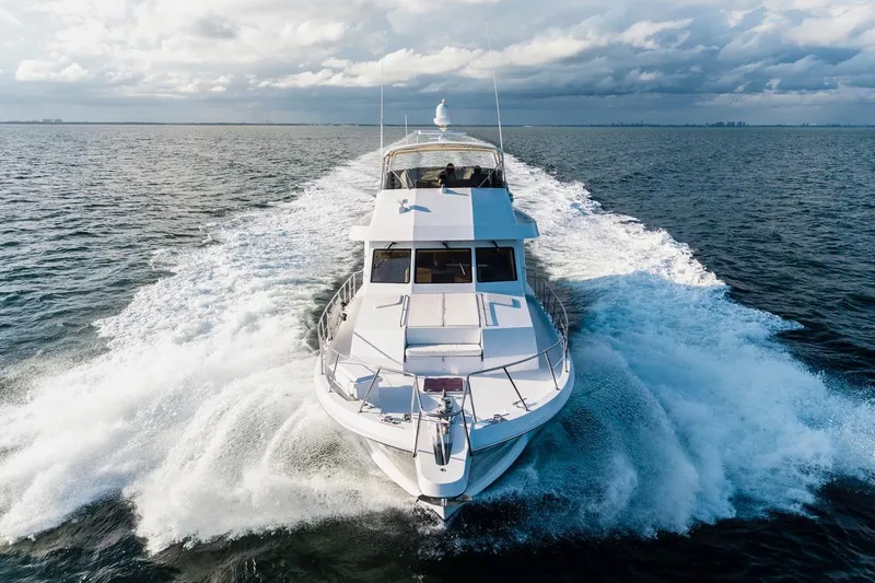  Yacht Photos Pics Hatteras 74 Cockpit Motor Yacht 2000 cruising on open water under cloudy skies.