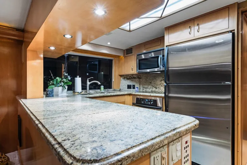  Yacht Photos Pics Luxurious kitchen interior of 2000 Hatteras 74 Cockpit Motor Yacht with granite countertops.