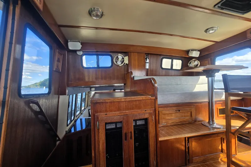 New Bearings Yacht Photos Pics Interior of 2000 Nordic Tug 42 Flybridge with wood finish and seating area.