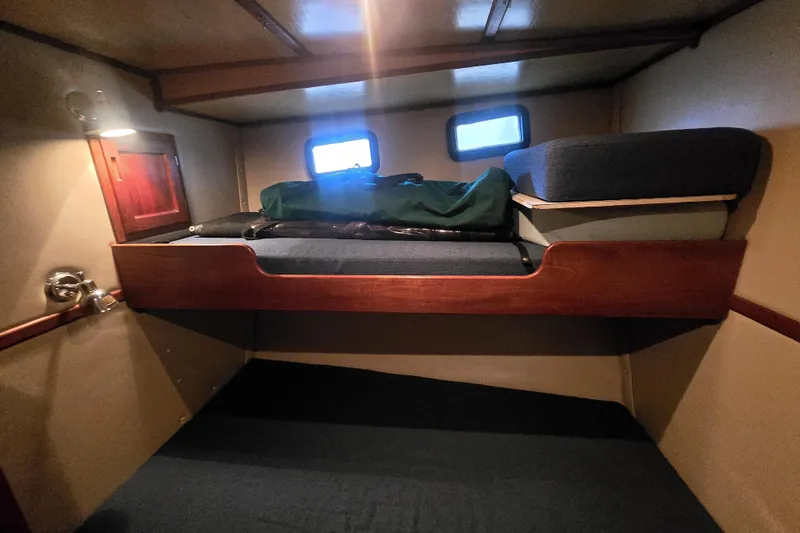 New Bearings Yacht Photos Pics Cozy cabin interior of 2000 Nordic Tug 42 Flybridge with bunk beds and porthole windows.
