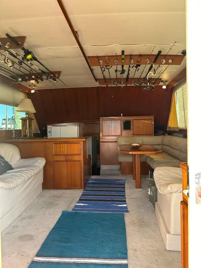 Charisma Yacht Photos Pics Interior of 1987 Post 46 SPORT yacht with fishing rods and cozy seating area.