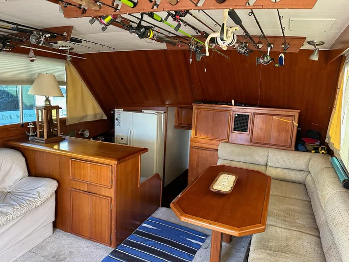 Charisma Yacht Photos Pics Interior of 1987 Post 46 SPORT yacht with fishing rods, wooden furniture, and cozy seating.