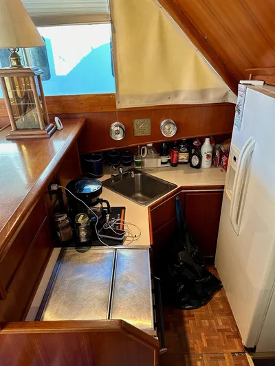 Charisma Yacht Photos Pics 1987 Post 46 SPORT yacht kitchen with sink, fridge, and wooden cabinetry.