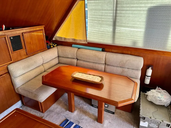Charisma Yacht Photos Pics Cozy interior of 1987 Post 46 SPORT yacht with wooden table and cushioned seating.
